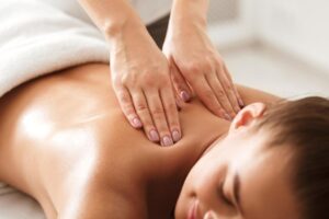Young woman enjoying therapeutic massage for stress relief in a spa.