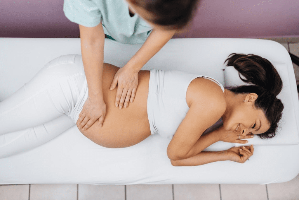 A pregnant woman enjoys and relaxes while receiving a prenatal massage from a therapist to help maintain a healthy pregnancy.