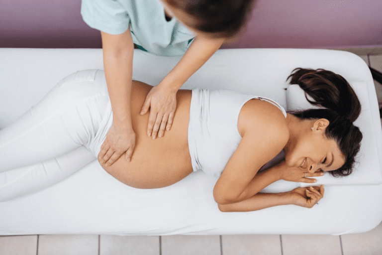 A pregnant woman enjoys and relaxes while receiving a prenatal massage from a therapist to help maintain a healthy pregnancy.