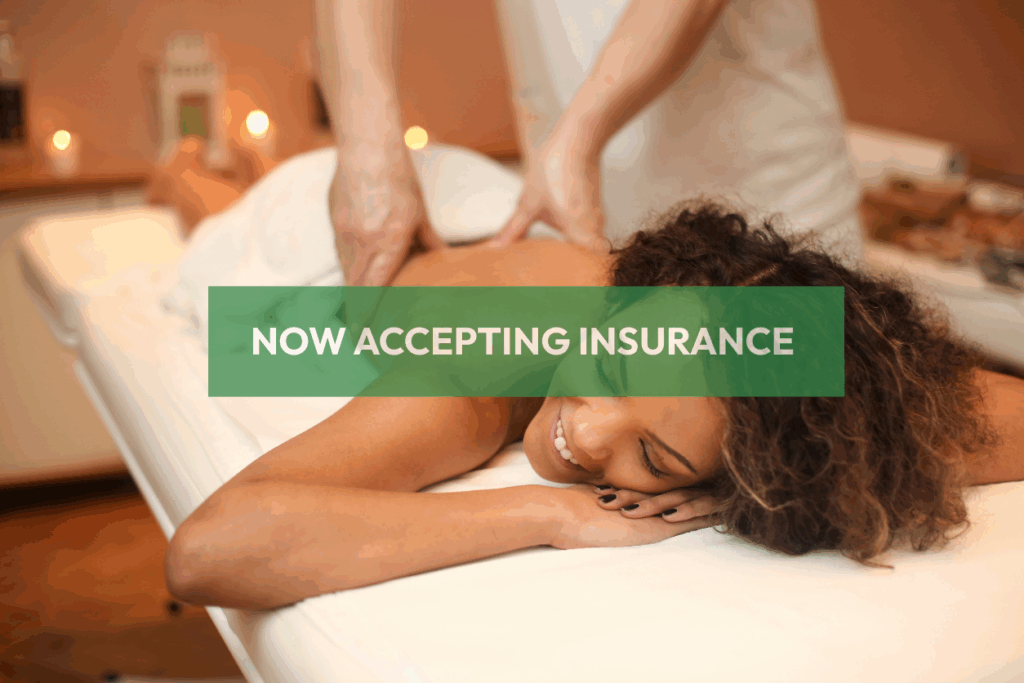 Smiling licensed massage therapist providing back massage to client—Naturally Zuri Massage now accepts NYSHIP and AETNA insurance.